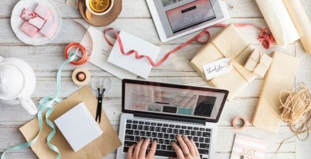 desktop with open laptop, robbon and cards strewn about