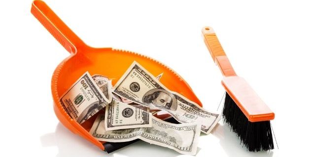 bright orange dustpan and brush with dollar bills in the pan